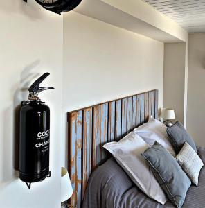 a bedroom with a bed with a black gas cylinder on the wall at Les gîtes du Canal du midi - Gîte Bois & Cailloux in Montgaillard-Lauragais