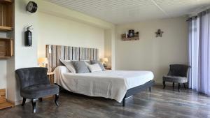 a bedroom with a bed and two chairs at Les gîtes du Canal du midi - Gîte Bois & Cailloux in Montgaillard-Lauragais