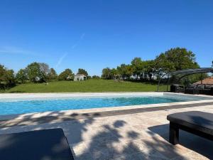 - une piscine avec vue sur un champ dans l'établissement La Millière - Gîtes, piscine & campagne, à Le Poiré-sur-Vie