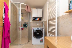 Waschmaschine und Trockner in einem kleinen Bad in der Unterkunft Appartamenti Marangon in Falcade
