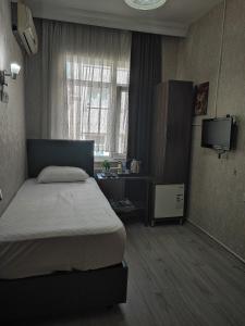a bedroom with a bed and a television in it at Fatih Hotel Erciyes in Istanbul