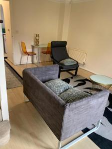 a living room with a couch and chairs and a table at Charming 2-Bed House in London in London