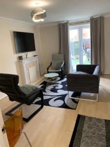 een woonkamer met 2 stoelen en een open haard bij Charming 2-Bed House in London in Londen