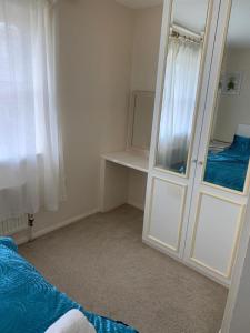 a bedroom with a mirror next to a bed and a mirror at Charming 2-Bed House in London in London