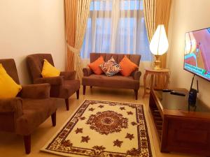 a living room with two chairs and a flat screen tv at MyHavelock Town Studio Apt, with Own Pvt Gate Parking in Main City in Nawala