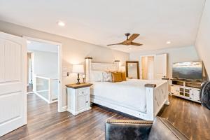 a bedroom with a white bed and a ceiling fan at Lake Nottely Escape in Mashburn Mill