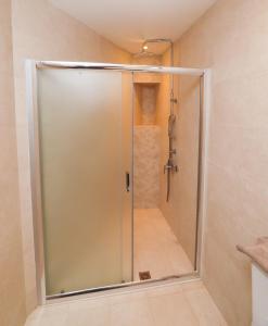 a shower with a glass door in a bathroom at East & West Seaside Apartments in Gialtra