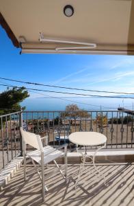 East & West Seaside Apartments في Gialtra: طاولة وكراسي على شرفة مطلة على المحيط