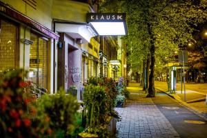 una calle de la ciudad por la noche con un cartel para una farmacia en Hotel Klaus K en Helsinki