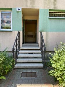 a staircase leading up to a building with a door at Apartament Gospodarcza in Sosnowiec
