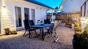 un patio con mesa y sillas frente a una casa en Newly built accommodation in Skrea - Falkenberg, en Falkenberg