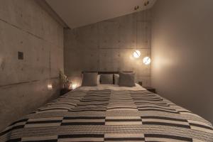 ein Schlafzimmer mit einem großen Bett und einer Betonwand in der Unterkunft VILLA WHITE in Sesoko