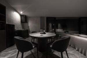 einen Tisch mit Weingläsern und Stühlen in einem Zimmer in der Unterkunft VILLA WHITE in Sesoko