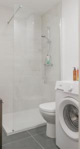 y baño blanco con aseo y lavadora. en Nouveau - Le Cosy6 - Centre Ville, en Phalsbourg