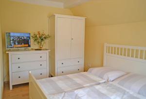 a bedroom with two beds and a white cabinet at Pension Pusch Inh_ Ursula Pusch in Guben