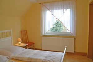 a bedroom with a bed and a christmas tree in a window at Pension Pusch Inh_ Ursula Pusch in Guben