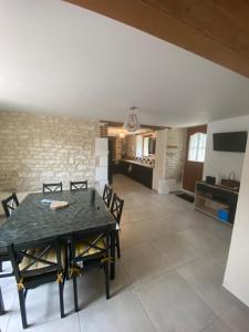 a dining room and living room with a table and chairs at Les Loisons in Beauvoir