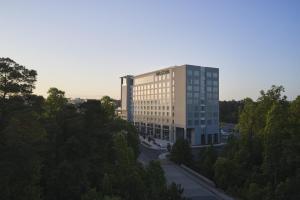 The Westin Raleigh-Durham Airport في رالي: مبنى مكتب طويل وبه أشجار أمامه