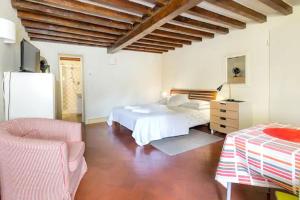 a bedroom with a white bed and a chair at Spacious studio apt (n.2) Ancient Palazzo in Florence