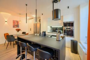 a kitchen with a large island with bar chairs at Suite Izambard - 6pers. in Charleville-Mézières