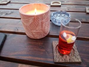 une bougie et un verre sur une table en bois dans l'établissement VILLA AVATOS - Near to the Port of Rafina and the Airport of Athens, à Áyios Spirídhon