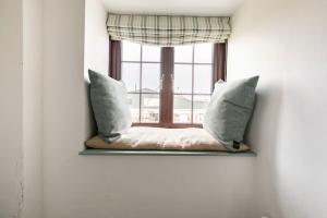 a window with two pillows and a window seat at Kota Restaurant & Rooms in Porthleven