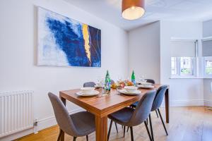a dining room with a wooden table and chairs at Hybrid Resi - New Malden near Richmond - Wimbledon in Malden