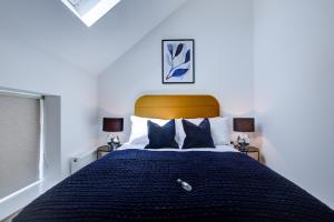um quarto com uma cama com um edredão azul e 2 candeeiros em Hybrid Resi - New Malden near Richmond - Wimbledon em Malden