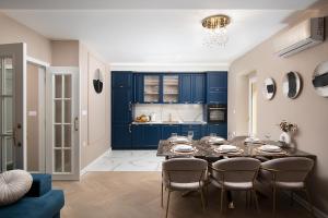 a dining room with blue cabinets and a table with chairs at Via Flavia Luxury Accommodation with FREE private parking in Pula