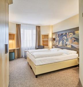 En eller flere senge i et værelse på Hotel Kaiserin Augusta