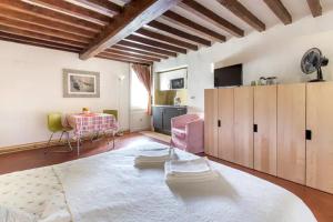 a living room with a table and a pink chair at Spacious studio apt (n.2) Ancient Palazzo in Florence