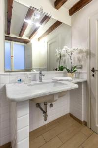 a white bathroom with a sink and a mirror at Spacious studio apt (n.2) Ancient Palazzo in Florence