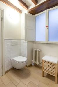 a white bathroom with a toilet and a window at Spacious studio apt (n.2) Ancient Palazzo in Florence