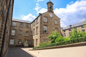 a large brick building with a clock tower on it at Foxglove Cottage in Harrogate