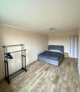1 dormitorio con 1 cama y suelo de madera en Cozy apartment in Kraslava, en Krāslava