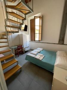 1 dormitorio con 1 cama y escaleras en una casa en B&B Le Donzelle - HiTuscany, en Pisa