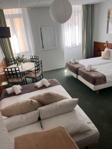 a hotel room with two beds and a table at Azurene Royal Hotel in Cannes