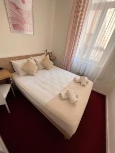 a bedroom with a large bed with two towels on it at Azurene Royal Hotel in Cannes