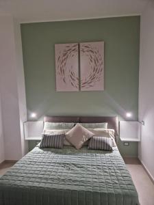 a bedroom with a large bed with two pillows at ondina house in Giardini Naxos