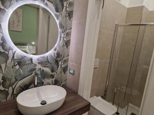 ein Bad mit einem Waschbecken und einem Spiegel in der Unterkunft ondina house in Giardini-Naxos