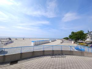 une plage avec une clôture bleue et une plage de sable dans l'établissement L'Instant Chic - L'Avenue des Voyageurs Côte d'Opale, à Boulogne-sur-Mer