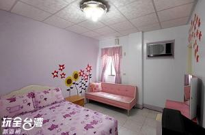 ein Schlafzimmer mit einem rosa Bett und einem rosa Sofa in der Unterkunft 綠島 梅蓮民宿 機車 潛水 浮潛 in Green Island