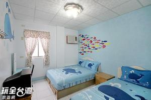 1 dormitorio con 2 camas individuales y ventana en 綠島 梅蓮民宿 機車 潛水 浮潛, en Isla Verde