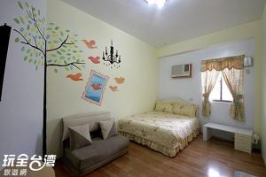 1 dormitorio con 1 cama y un árbol en la pared en 綠島 梅蓮民宿 機車 潛水 浮潛, en Isla Verde