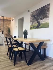 une table en bois avec des chaises et une plante en pot. dans l'établissement Casa Rural "El Cañuelo", à Aljucén