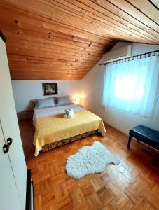 a bedroom with a bed and a wooden ceiling at Buble Summer House in Rab