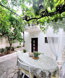 a patio with a table and chairs in a yard at Buble Summer House in Rab