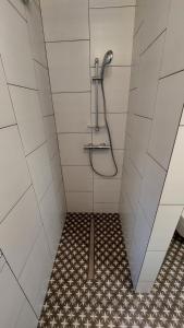 a bathroom with a shower with a tiled floor at Black&White in Mrągowo +8 photos