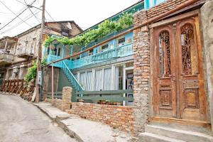 un ancien bâtiment en briques avec une grande porte en bois dans l'établissement OLD Tbilisi ! Старый Тбилиси, à Tbilissi