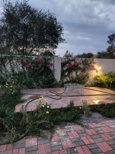 un giardino con patio fiorito e recinto di Josmot Guest House a Gaborone